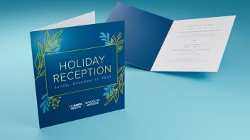 Two bi-fold invitation cards sitting on a blue surface.