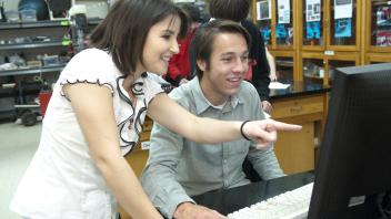 Photo of people looking at a computer screen