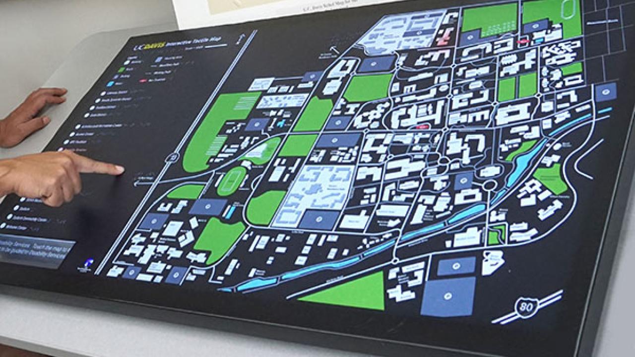 Joshua uses his finger and audio signals to determine proximity to select buildings, with captions appearing in the bottom left corner